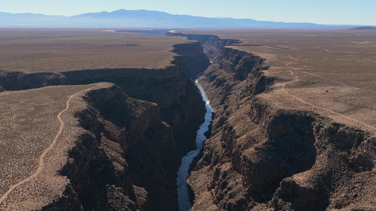 Il fiume Rio Grande serpeggia in modo spettacolare tra imponenti pareti di canyon. Il movimento del fiume evidenzia l'immensa scala di questo arido paesaggio del Sud-Ovest.