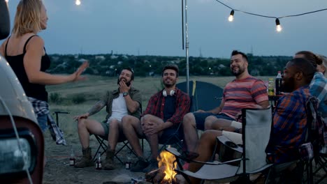 laughing diverse friends playing charades in camp