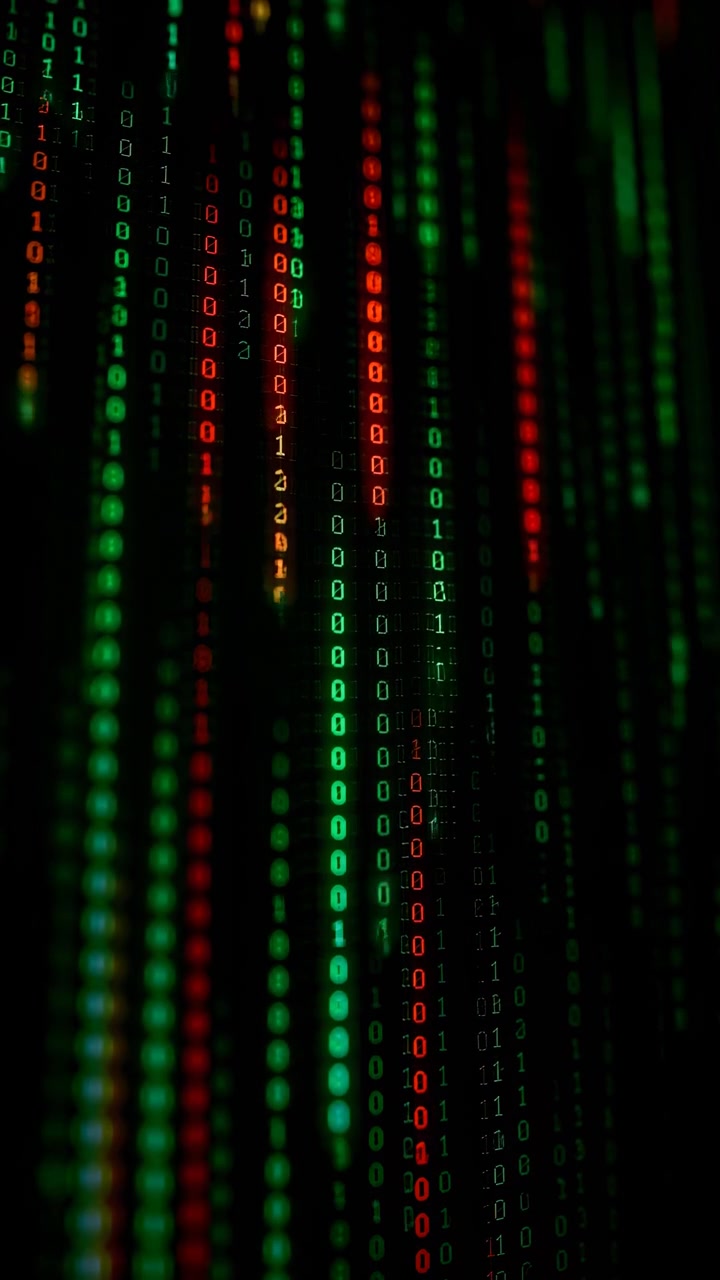Lyse binære tal bevæger sig gennem lodrette kolonner på mørk baggrund, med grønne, røde og orange lysspor der skifter i dybden for at skabe abstrakt dataflow og cyberteknologi-billedsprog.