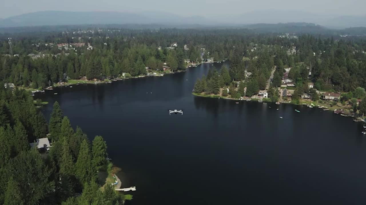 Drohnenflug über den Pipe Lake im Bundesstaat Washington mit ruhigem Wasser, umgeben von üppig grünen Kiefern