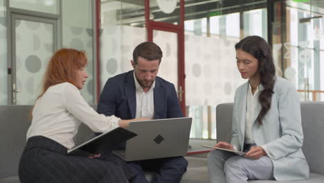 Equipo-De-Trabajo-Compuesto-Por-Dos-Mujeres-Y-Un-Hombre-En-Una-Reunión-Poner-Cosas-En-Común