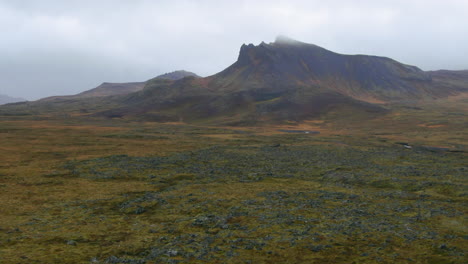 Drone-view-of-Icelandic-mountains-on-an-overcast-day-with-a-rocky-and-grass-covered-valley