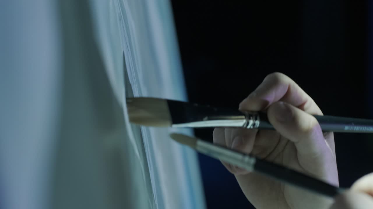 dos pinceles dibujan trazos en la pizarra. primer plano. pintor de velocidad