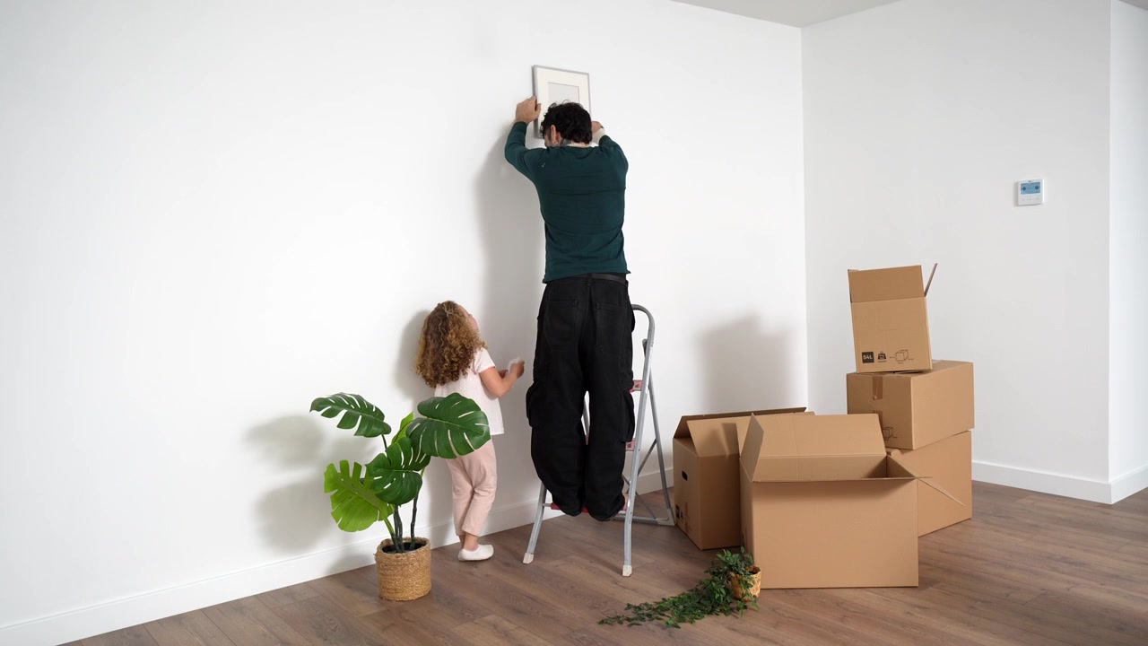 Father and Daughter Decorating New Home Together