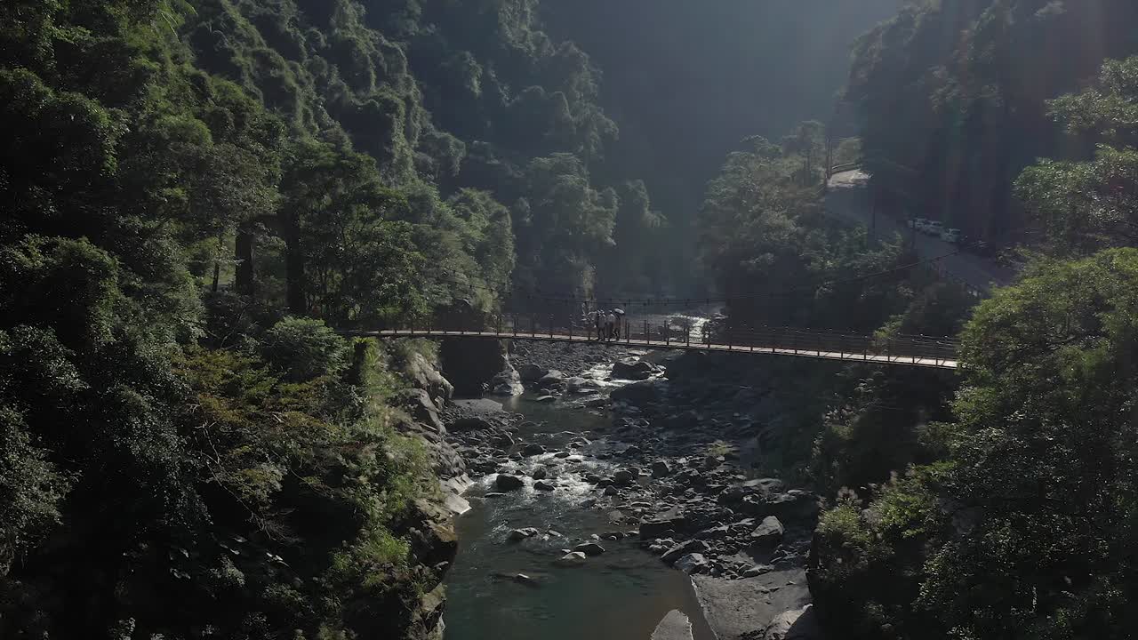 Suspension Bridge Over River in Mountainous Landscape