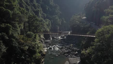 suspension bridge over river in mountainous landscape
