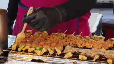 street food vendor preparing grilled skewers