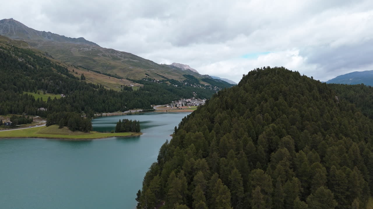 Tranquillo lago vicino a Silvaplana, con vista su una lussureggiante foresta e cielo nuvoloso