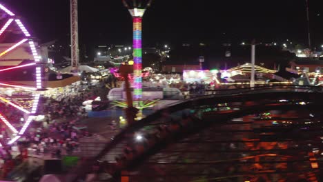 people rides on thrilling roller coaster at washington state fair at night