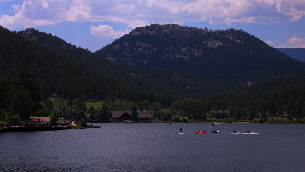 Sommer, Evergreen See, Paddleboarding, Kanu, Kajak, Boote, Wassersport, Luftaufnahme Drohne, Evergreen Colorado, Vorgebirge, Denver Golfplatz, Front Range Rocky Mountains, sonnig, bewölkt, Morgendunst, Schwenk nach links.