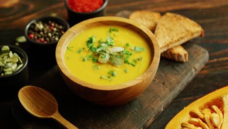 fresh pumpkin soup in bowl on chopping board