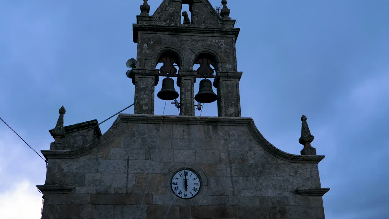 Ripresa con drone in allontanamento da un gargoyle coperto di muschio e dalla croce del campanile per rivelare un vasto paesaggio di Ourense, Spagna.