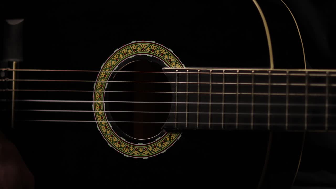 一位吉他手在工作室中演奏吉他,灯光很亮