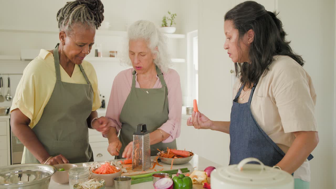 Diverse women in aprons after left woman's gasp peeling carrot and grating on grater prepping