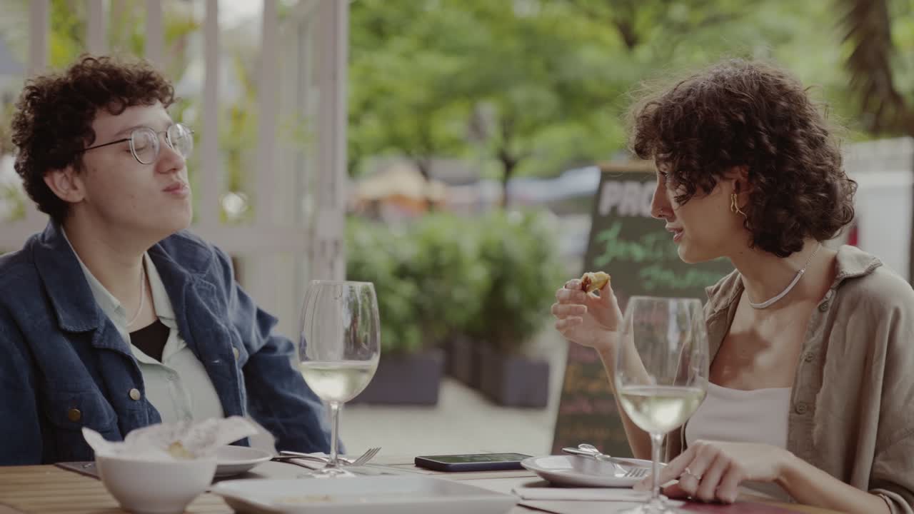 Friends enjoying a meal and conversation at an outdoor restaurant