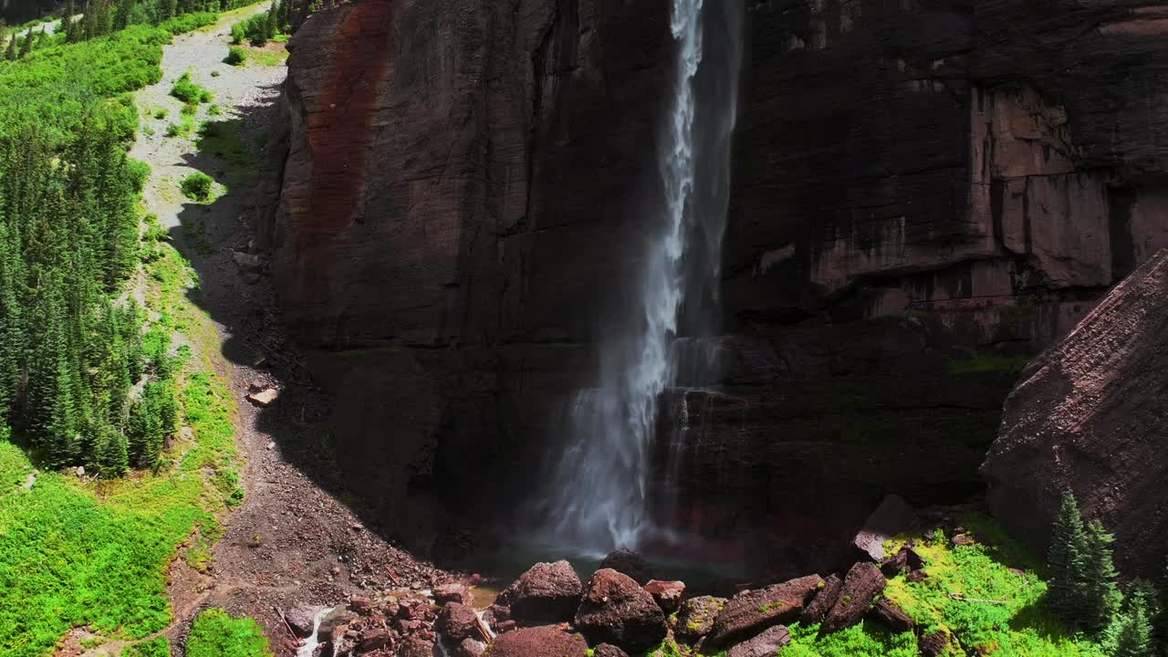 Summer green Telluride Bridal Veil Falls Waterfall Colorado powerplant house aerial drone Box Canyon Black Bear Pass Road Rocky Mountains 4wd hiking blue sky cliffs Uncompahgre Forest backwards pan up
