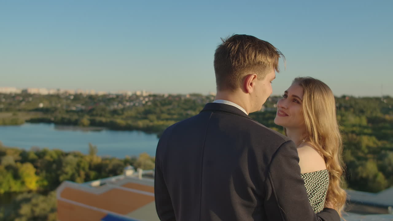 지붕에서 만적인 데이트: 사랑하는 커플이 해가 지는 지붕에서 데이트합니다.