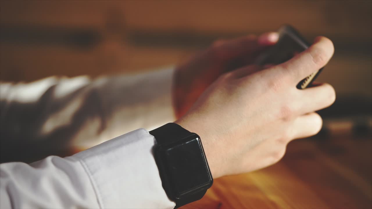 persona que utiliza un teléfono inteligente y un reloj inteligente