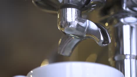 espresso pouring into a cup from a coffee machine