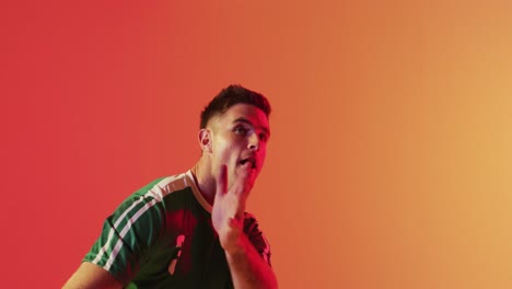 jugador de fútbol masculino caucásico regresando el fútbol con la cabeza sobre la iluminación rosa de neón
