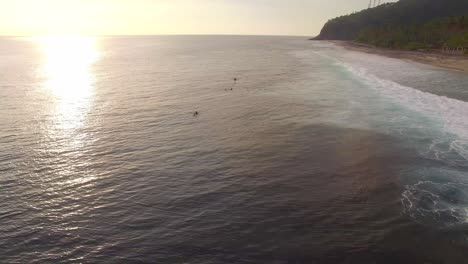 surfers in picturesque bay at sunset