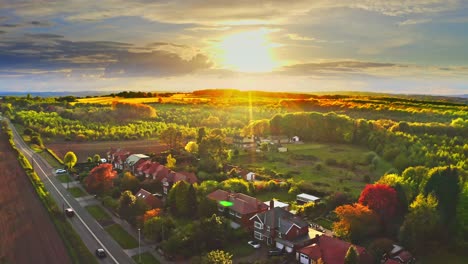 aerial drone shot rising up over countryside housing estate in golden hour