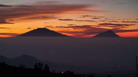 Hermoso-Paisaje-Cielo-Rojizo-Del-Amanecer-Con-Dos-Montañas