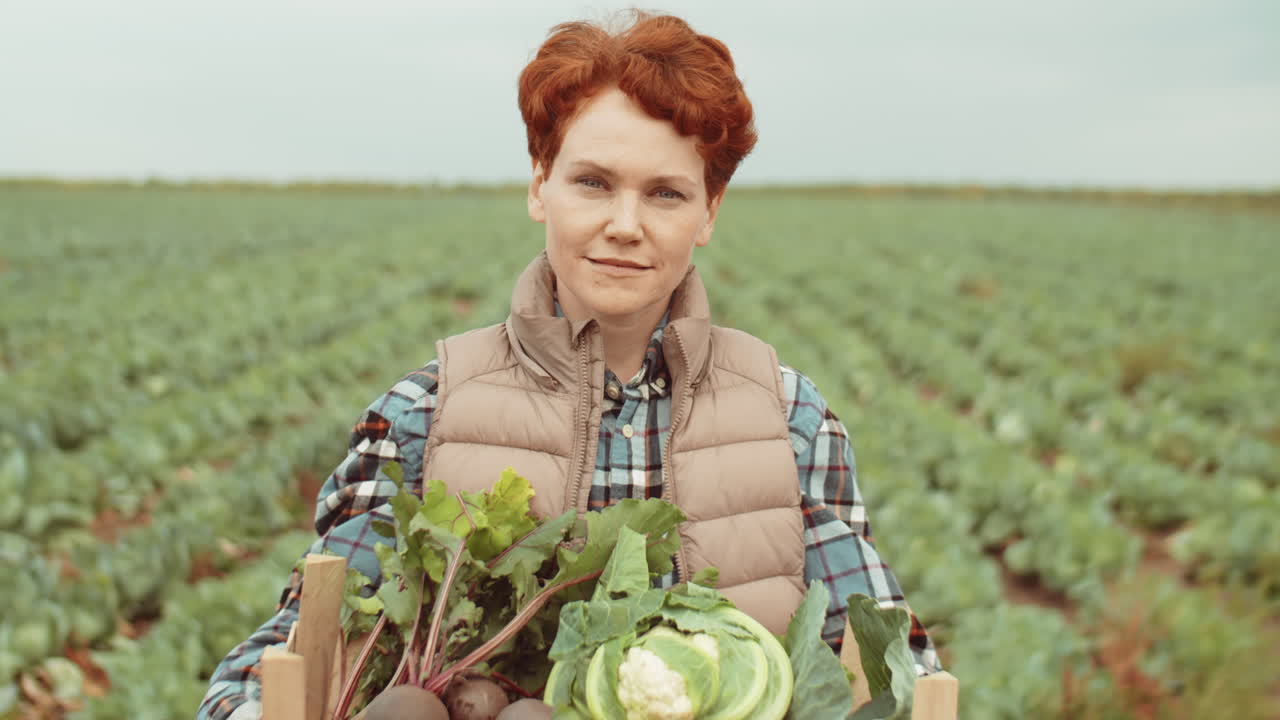 retrato de una agricultora con una caja de verduras frescas