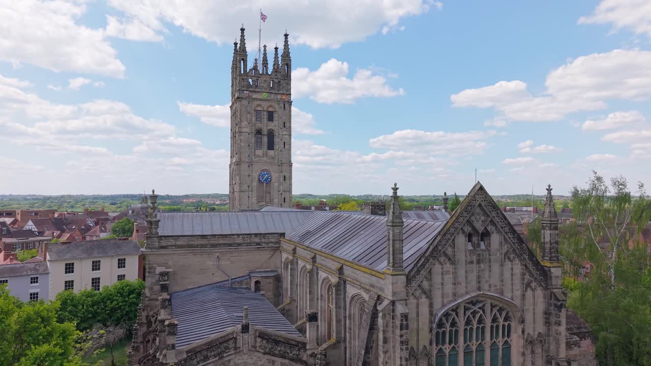 Riprese drone in ascesa sopra la chiesa gotica di St Mary a Warwick, che rivelano gradualmente il paesaggio urbano storico, mostrando l'architettura medievale, il patrimonio inglese e il carattere della città.