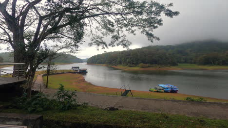 A-beautiful-panning-shot-of-a-beautiful-scenery-with-rain-forest,-lake-and-mountains-with-a-foggy-climate-taken-from-kerala,-INDIA