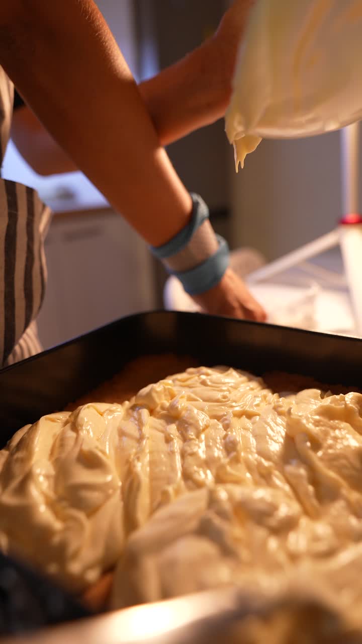 Nærbilde av hender som heller kremet røre i bakeform
