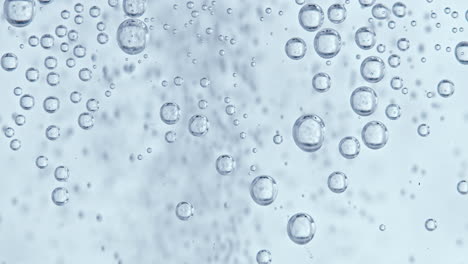 Water-bubbles-with-white-background,-static-bubbles-in-the-foreground-and-fast-moving-smaller-bubbles-in-the-background