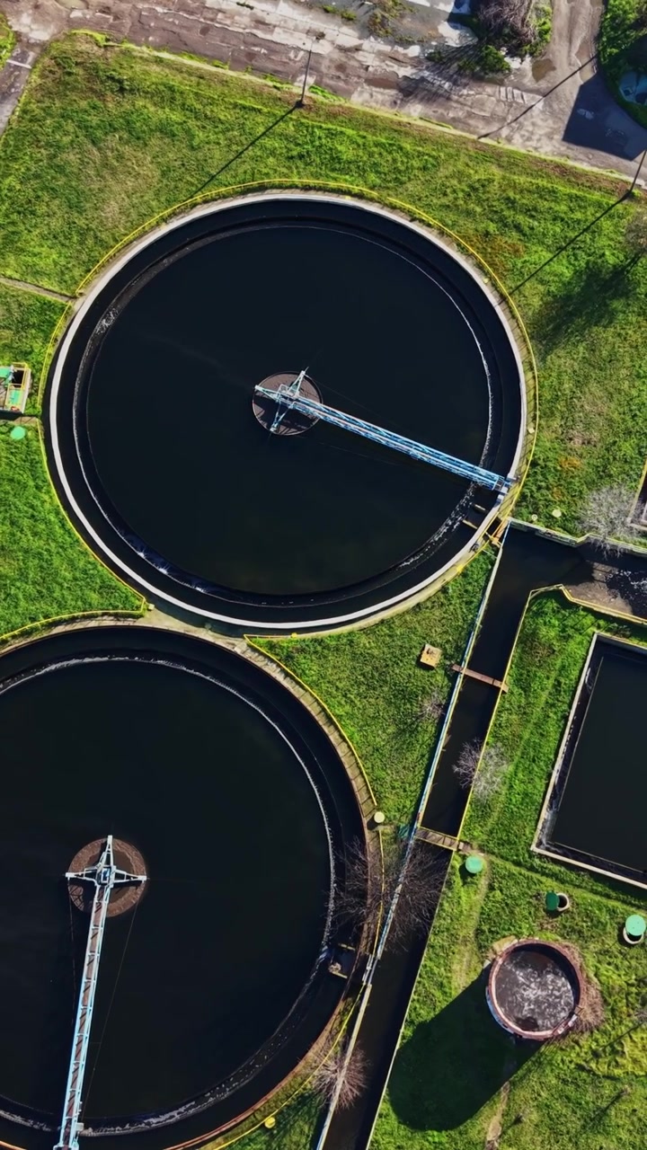 Wastewater treatment facility with circular tanks in green area