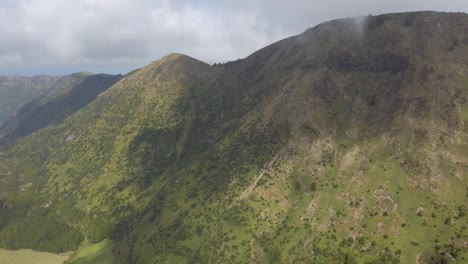 gimbal pan of girl walking toward peak of miradouro da boca do inferno, sao miguel, portugal