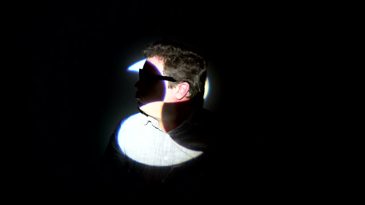retrato de un hombre gordo en un haz de luz multicolor.
