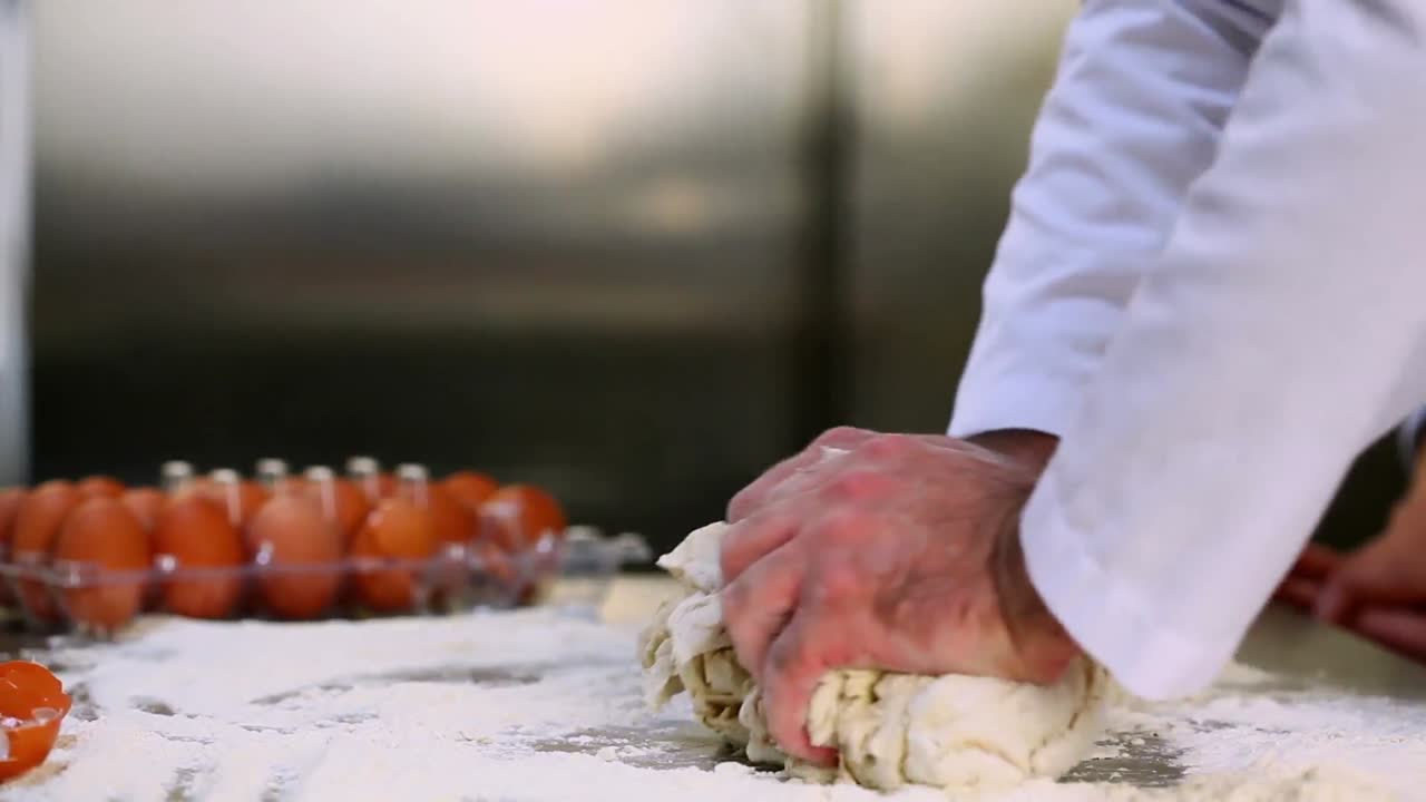 Mani di chef che impastano