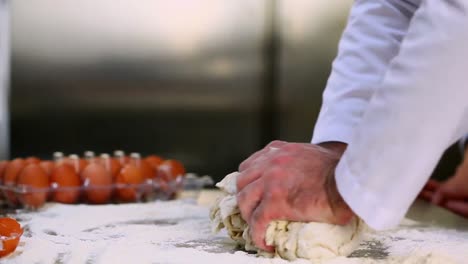 chefs hands kneading out dough