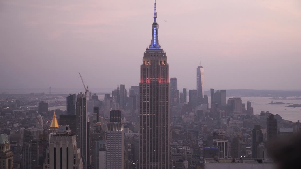 O icônico Empire State Building ao anoitecer após o pôr do sol em Nova York, em câmera lenta.