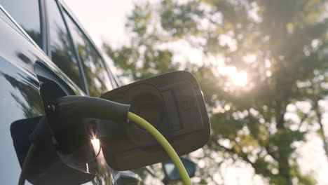 power cable connected with a charger plugged into an electric car, close up