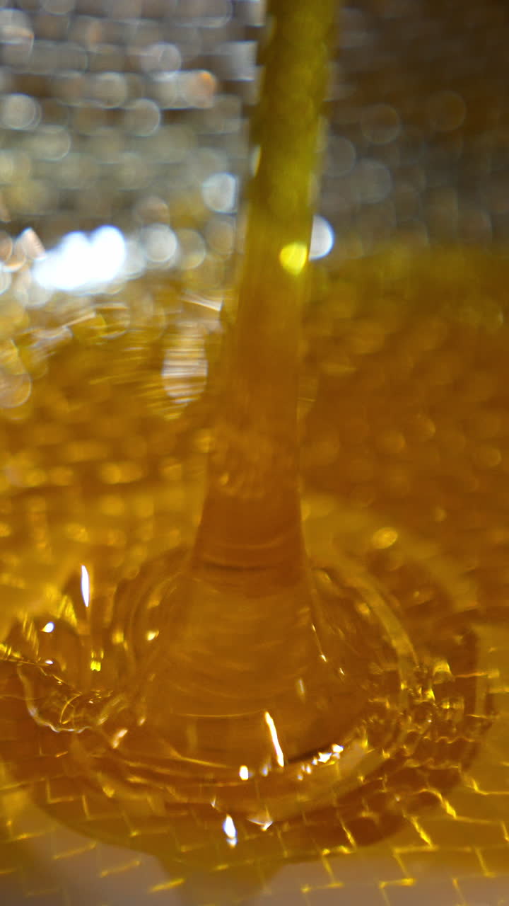 Sweet honey pouring close up view. Fresh natural honey flowing. Vertical video