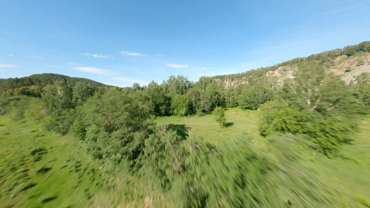 Beautiful natural areas in the suburban area. The concept of preserving the environment. A variety of tree species growing in the river valley. Mountains in the background.