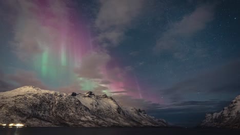 Erstaunliche-Rote-Und-Grüne-Aurora-Vorhänge-Füllen-Einen-Sternenhimmel-über-Den-Winterlichen-Bergen-Im-Norden-Norwegens