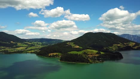 Aerial-view-of-mountain-lake-Mondsee-along-the-coast-of-Sankt-Lorenz,-Austria