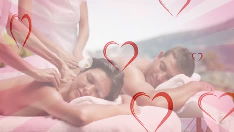 animation of hearts falling over caucasian couple in spa during massage