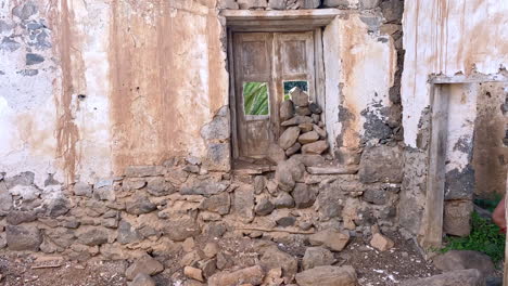 a woman is walking by an old stone house in betancuria, fuerteventura