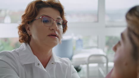 cosmetologist consulting woman facial procedures close up. lady examining skin.