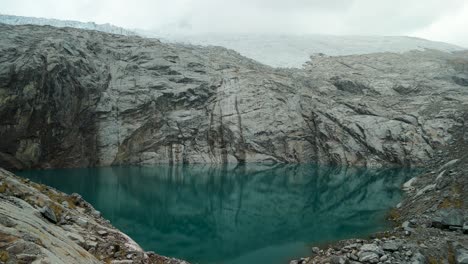 a spectacular aerial parallax shot orbits the majestic landscape of paso del zorro in the peruvian andes, revealing a vast glacier and a pristine, high-altitude alpine lake