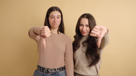 disapproving female friends showing thumbs down