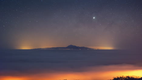 lapso de tiempo de la vía láctea que se eleva sobre el monte teide visto desde la isla de la palma