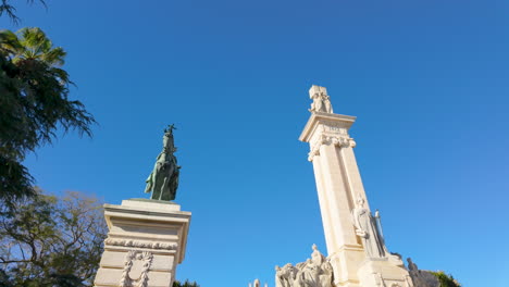 Equestrian-statue-under-blue-sky,-framed-by-tropical-trees-and-historic-architecture,-clear-day